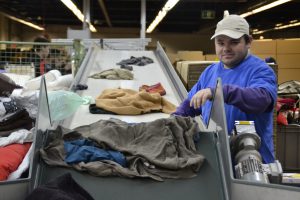 Kevin Cuylaerts aan het werk aan de sorteerlijn van De Kringwinkel Zuiderkempen